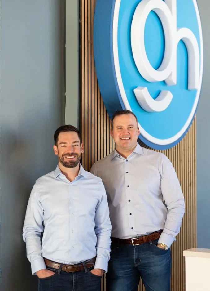 Drs. Guidry and Horaist standing in front of the Guidry & Horaist Orthodontics logo, showcasing their expertise in orthodontic care in Morgan City, LA.